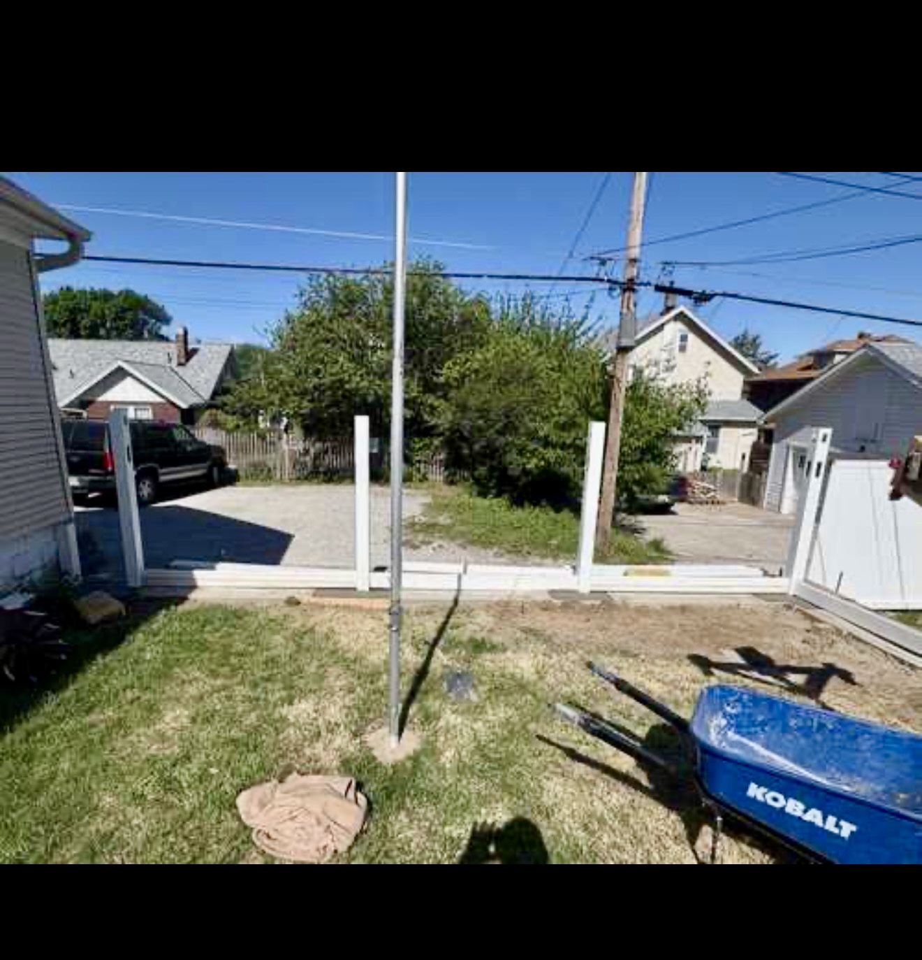 White vinyl fence installation with posts and panels in progress