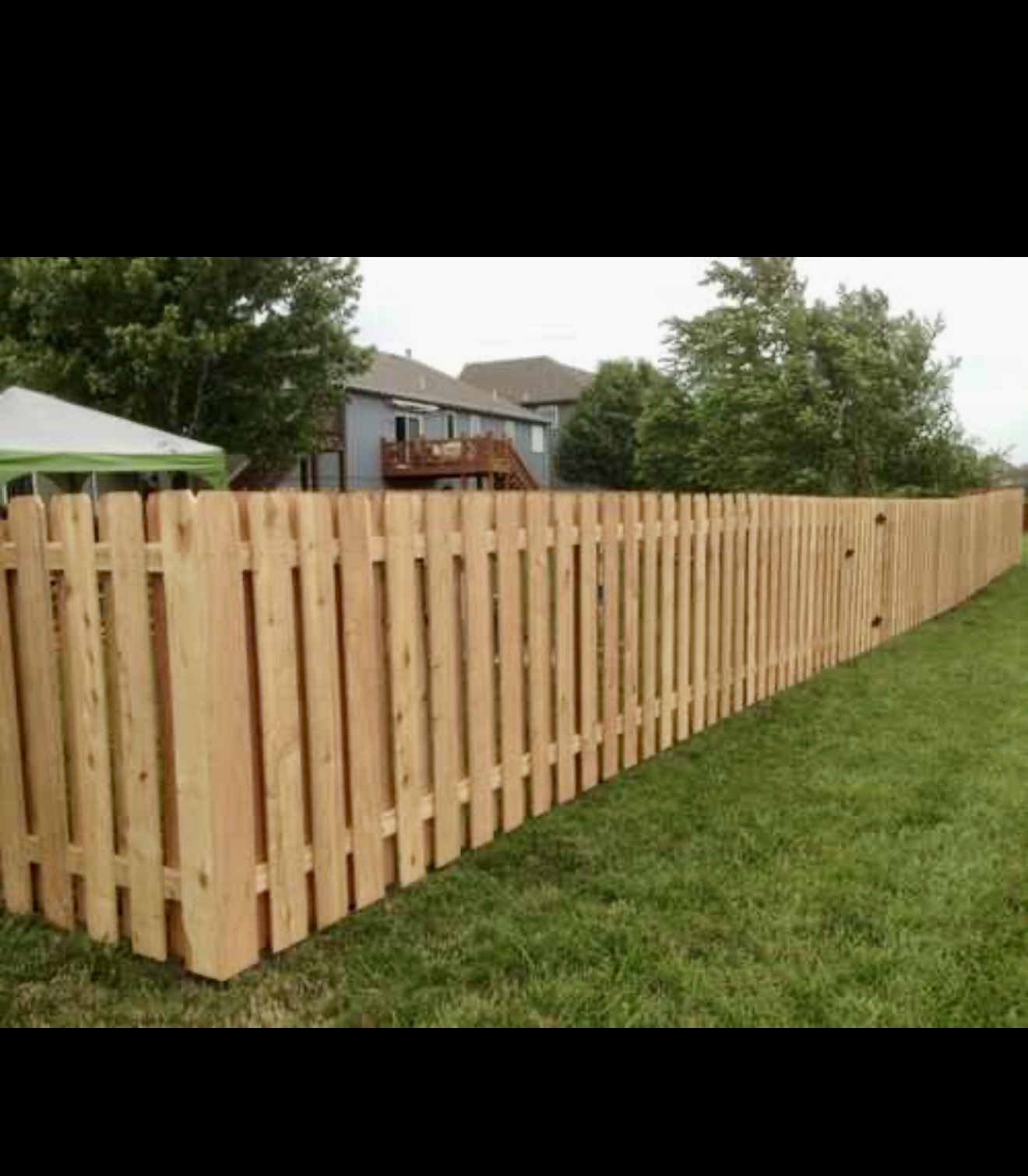 Wood fence installation with scalloped fence detail
